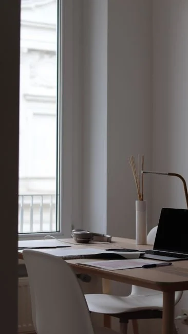 Un laveur de vitres en extérieur nettoie depuis le dessus une verrière en verre avec un outil, en plein jour.